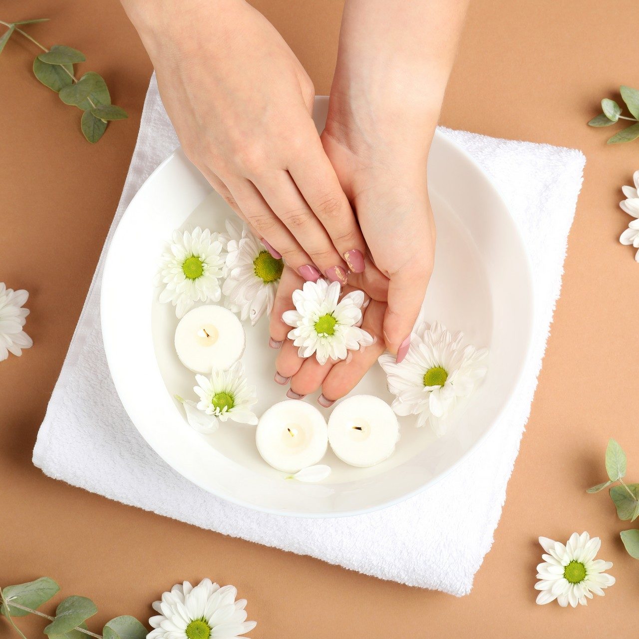 Concept of hand care on beige background with flowers